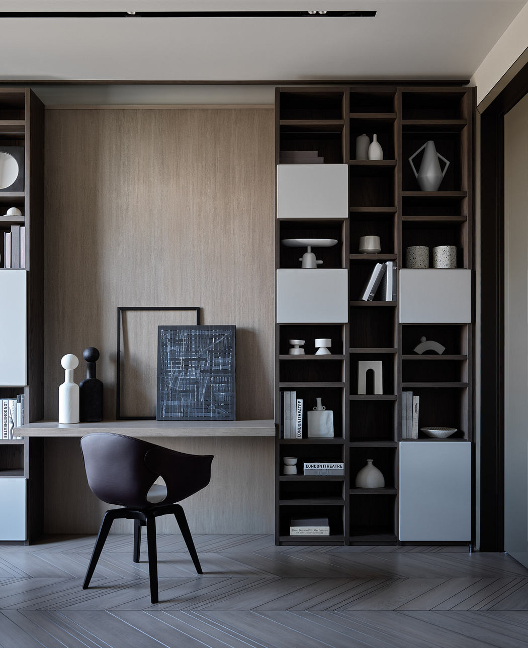 A modern, minimalist home office with a wooden accent wall, built-in shelving, and a stylish black chair.