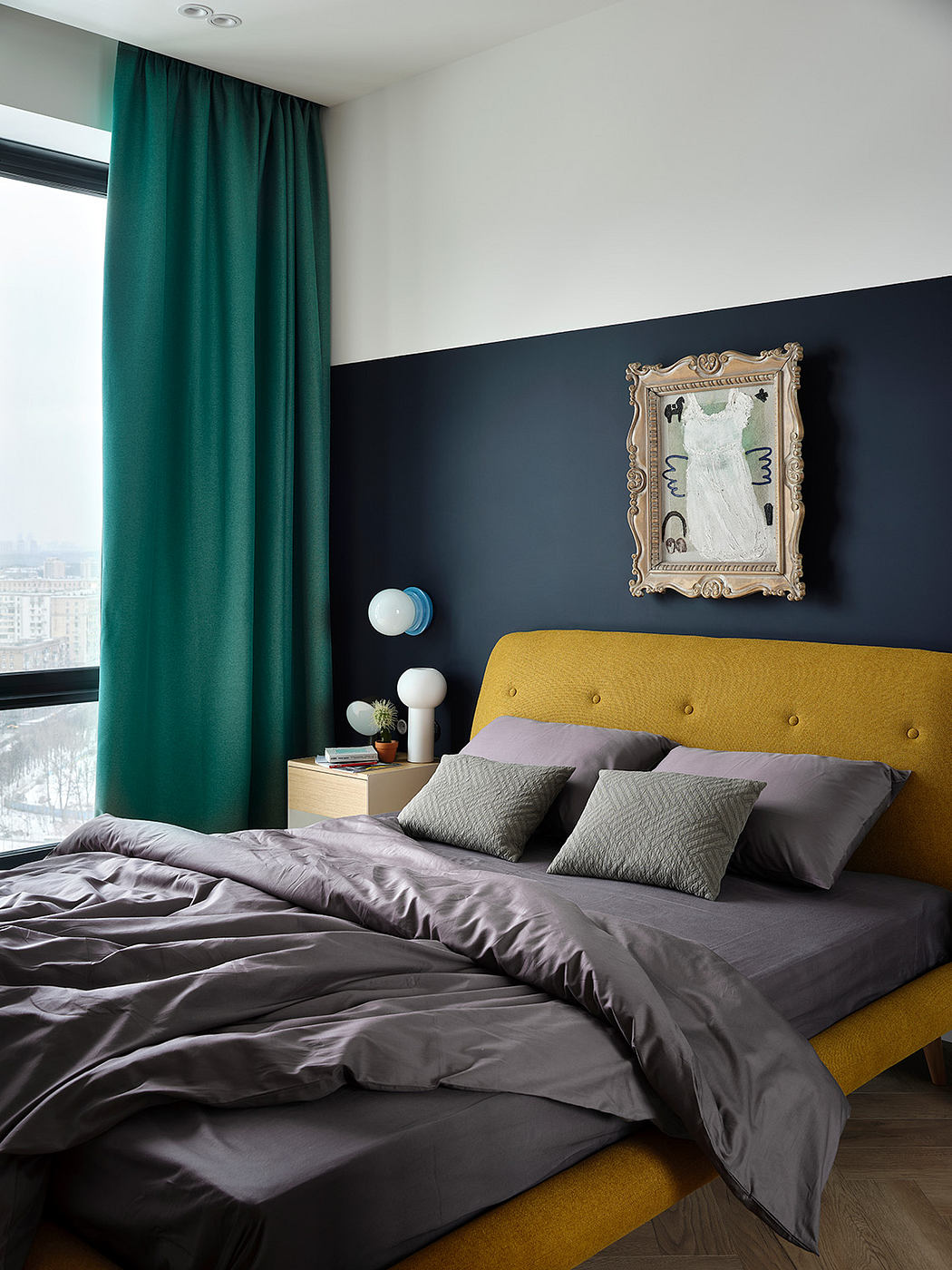 Elegant bedroom with dark accent wall, ornate framed artwork, and plush textiles.