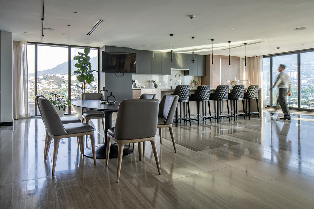 Elegant modern dining and kitchen area with floor-to-ceiling windows, sleek furnishings.