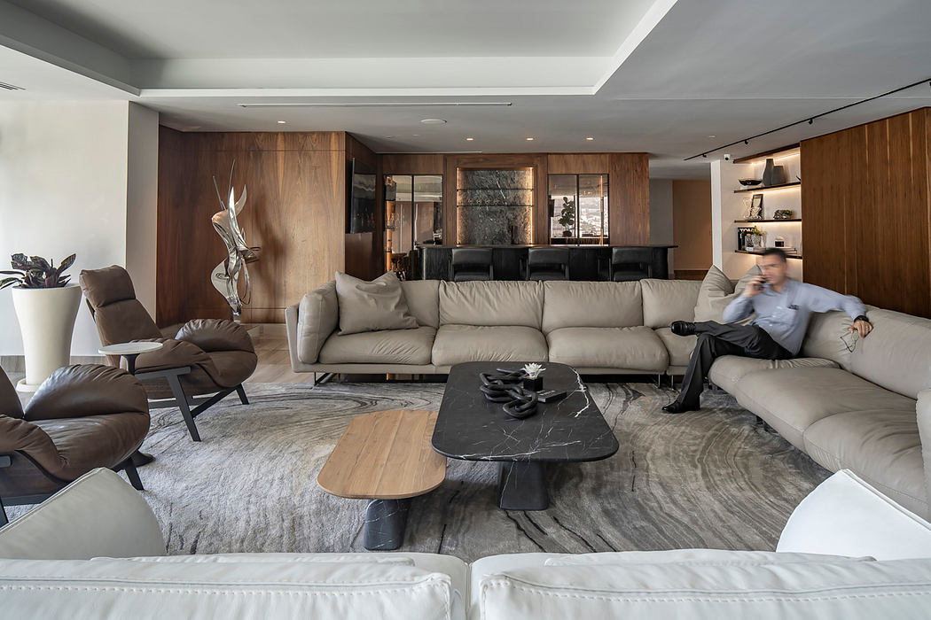 Luxurious open-concept living room with modern furniture, wooden accents, and a marble coffee table.