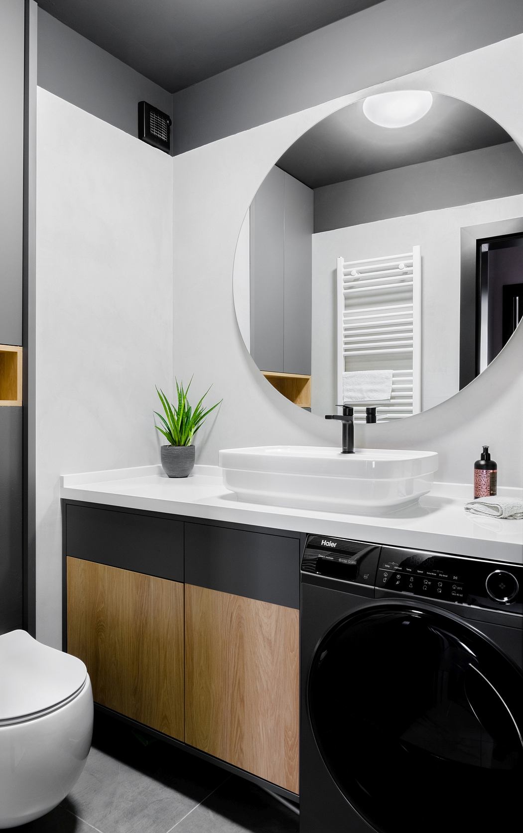 Sleek modern bathroom with minimalist vanity, vessel sink, and black washer.