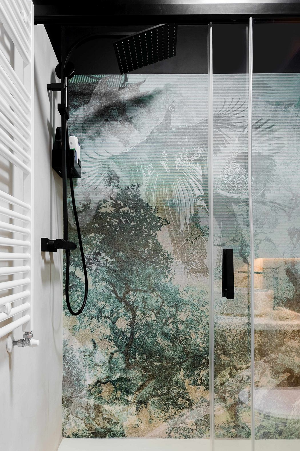 A modern, minimalist shower enclosure with a striking abstract glass panel.