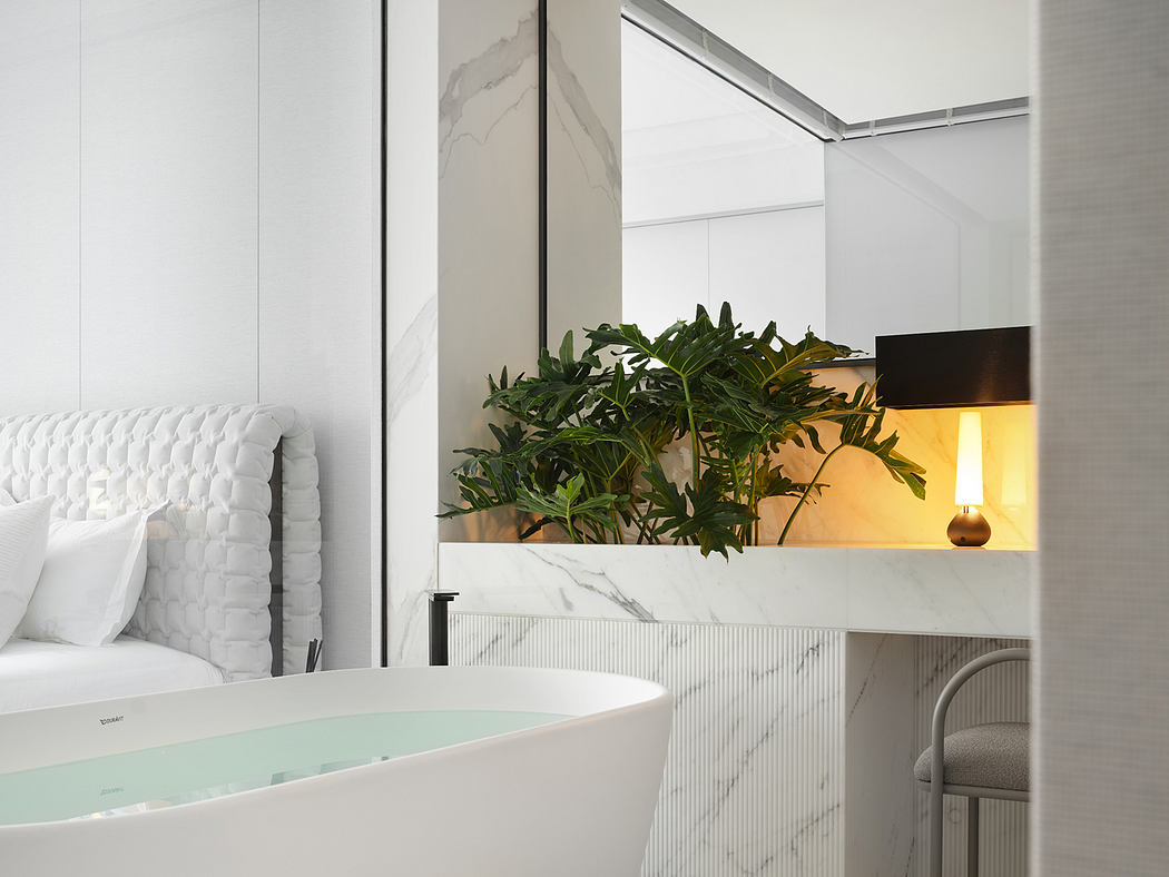 A sleek, modern bathroom with a marble-clad vanity and lush tropical plants.