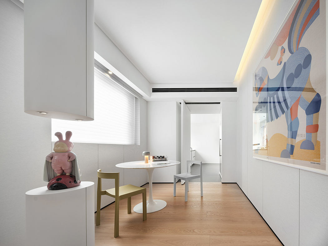 A modern and minimalist kitchen interior with a colorful abstract artwork, round dining table, and minimalist chairs.