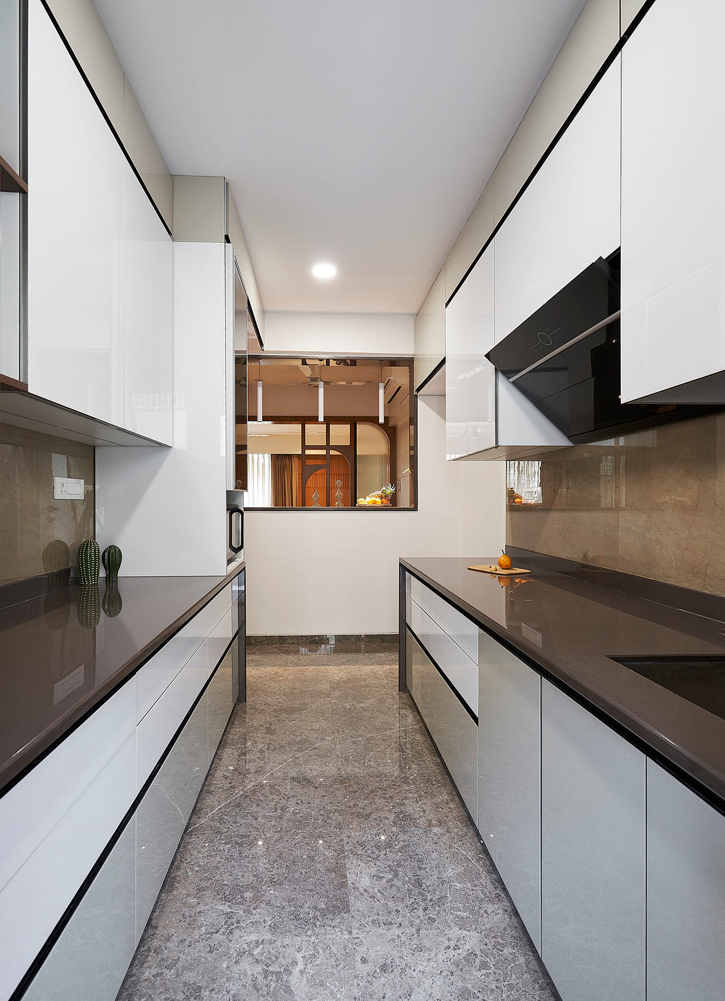 Sleek, modern kitchen design featuring white cabinetry, black accents, and gray marble flooring.