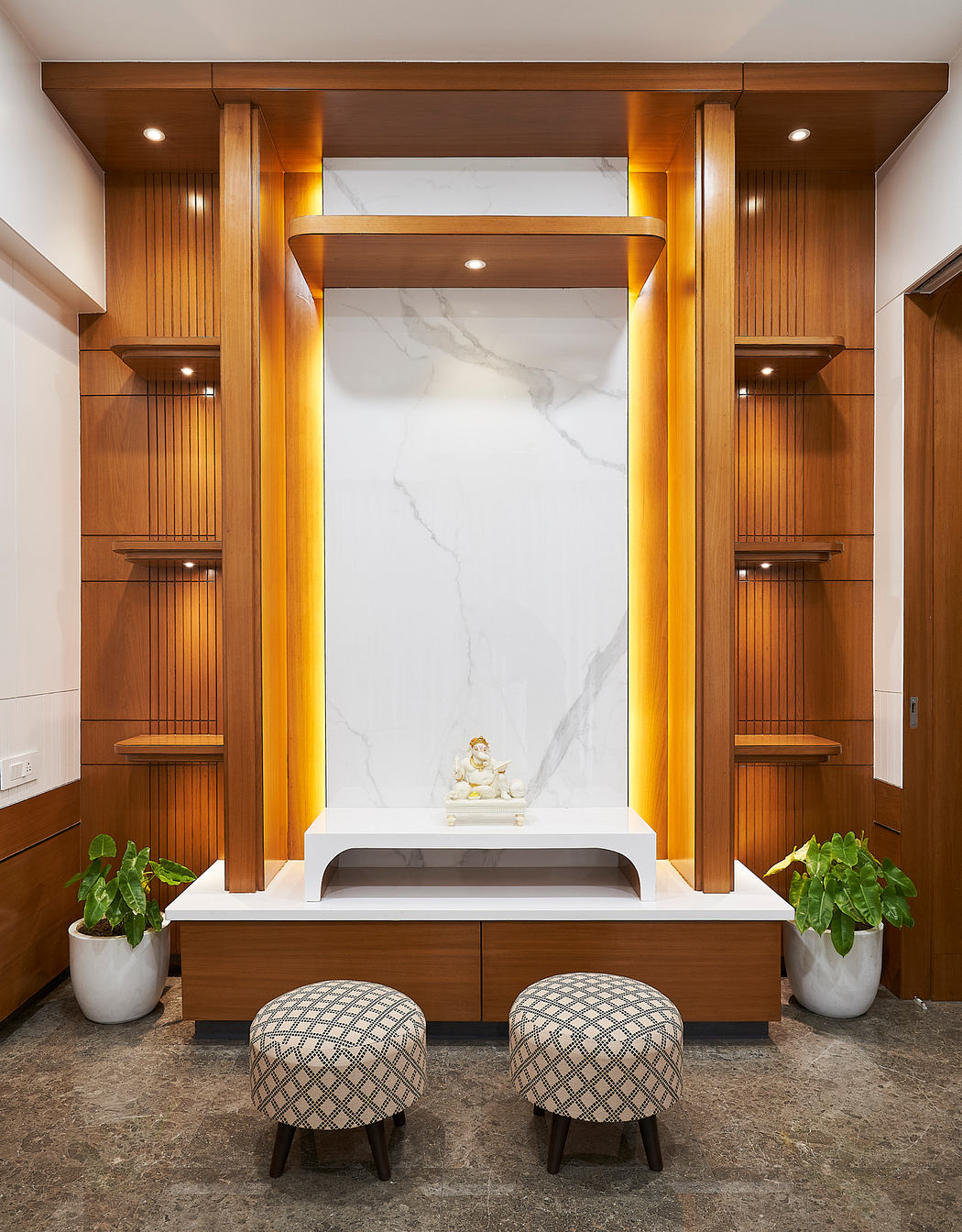 Elegant wooden cabinetry, marble backsplash, and decorative shelves in modern entryway.