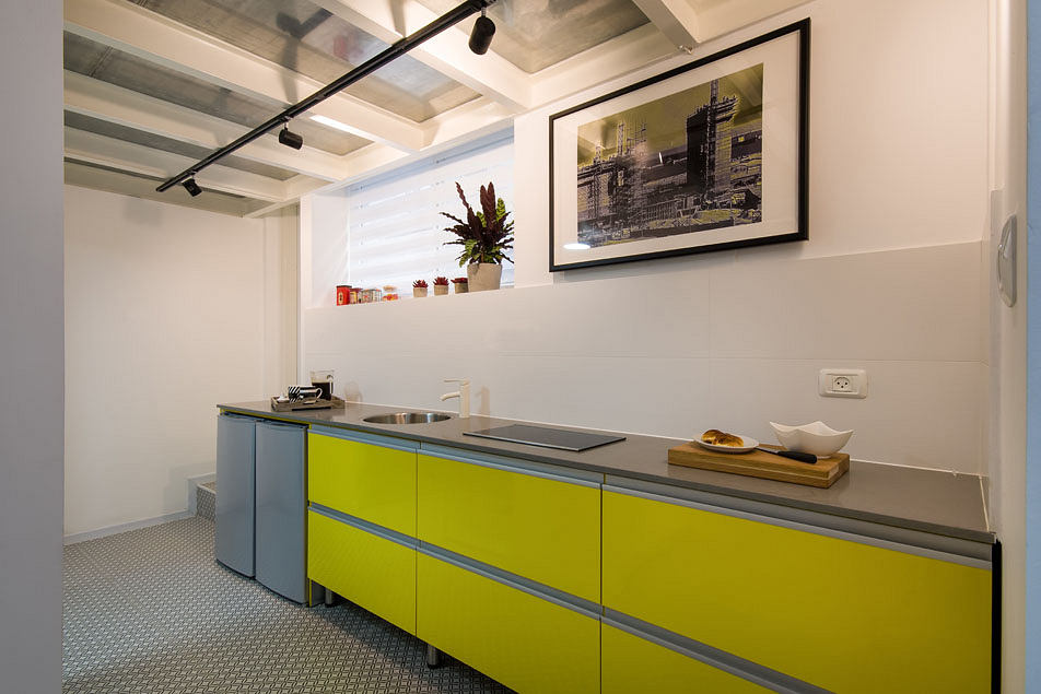 Bright, modern kitchen with bold yellow cabinetry, industrial decor, and artwork.