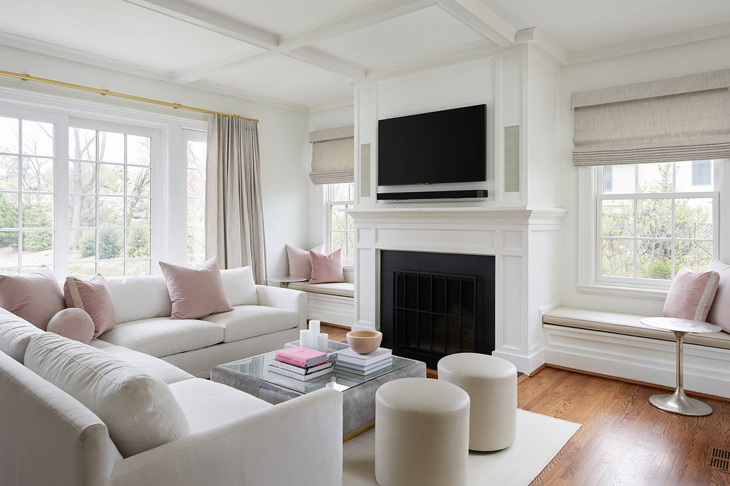Spacious living room with white walls, large windows, and a fireplace with a mounted TV above.