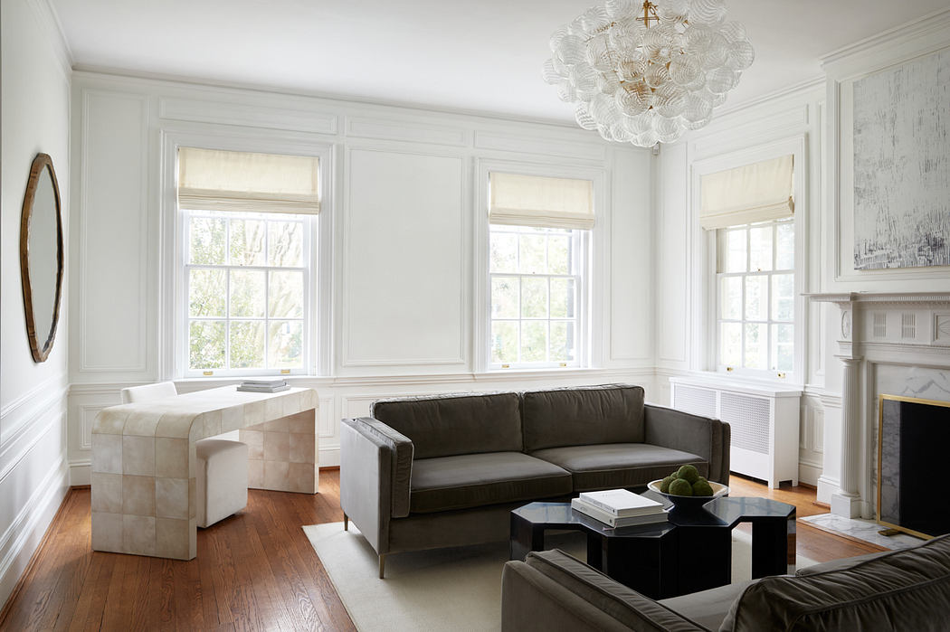 A bright, spacious living room with tall windows, white walls, and a modern chandelier.