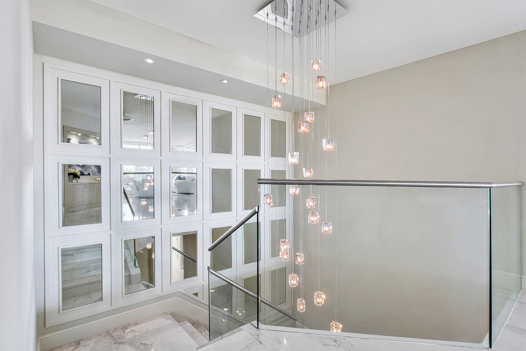 Elegant foyer with floor-to-ceiling mirrored cabinetry and a stunning cascading light fixture.