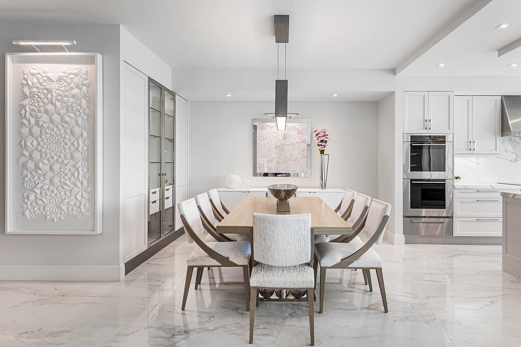 Sleek, modern dining room with minimalist decor, glass-walled cabinetry, and marble flooring.
