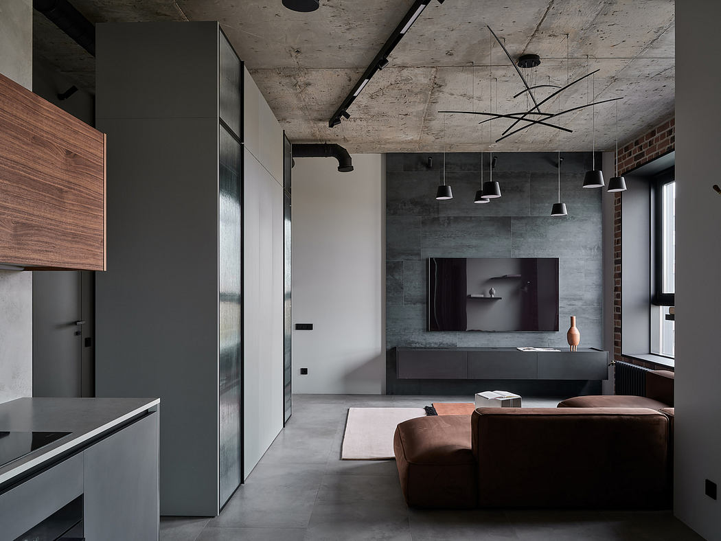 A modern, industrial-style interior with concrete walls, minimalist furniture, and pendant lighting.