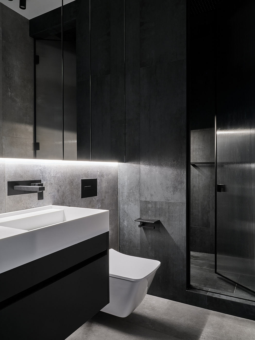A sleek, modern bathroom with black and white tones, minimalist fixtures, and textured walls.