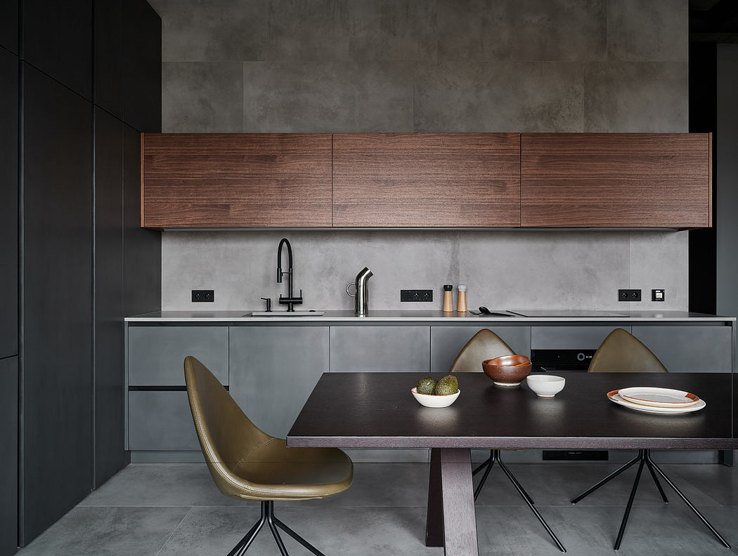 Modern kitchen with sleek gray cabinets, wooden countertops, and metallic chairs.