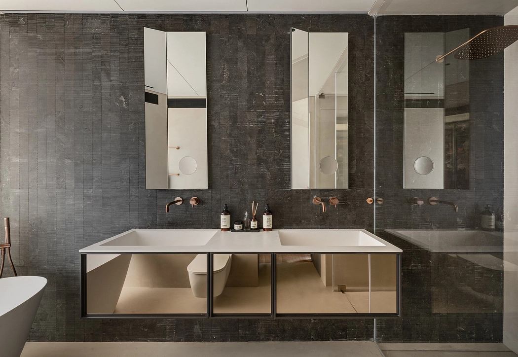 Luxury bathroom with sleek, minimalist design featuring stone walls, mirrored vanity, and brass fixtures.