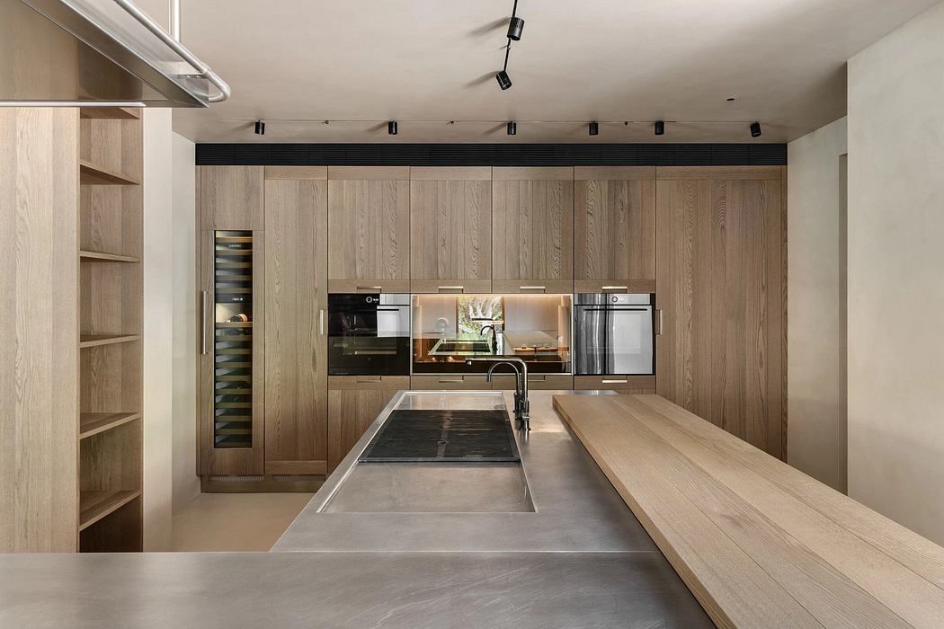 Warm, modern kitchen with wooden cabinetry, sleek appliances, and minimalist design.