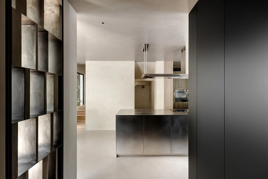 Sleek, minimalist kitchen with black cabinetry, stainless steel appliances, and modern lighting.