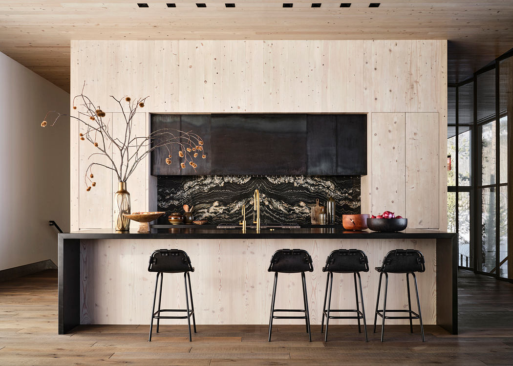 Rustic wood paneled kitchen with dramatic black backsplash, bar stools, and pendant lighting.