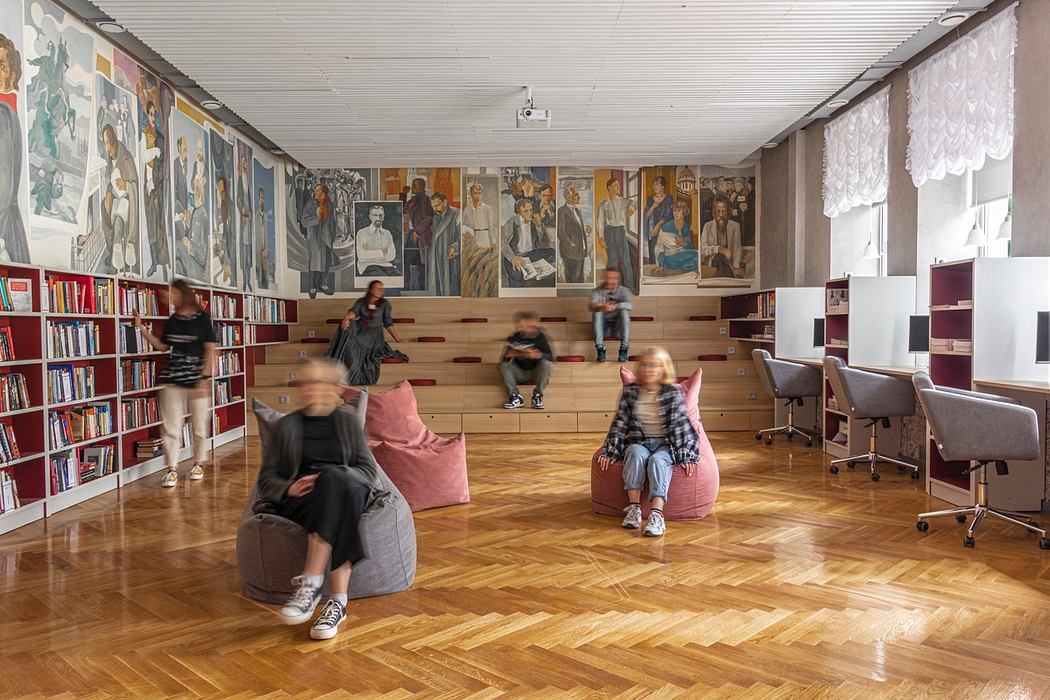 Expansive classroom with wooden floors, bookshelves, and vibrant wall murals.