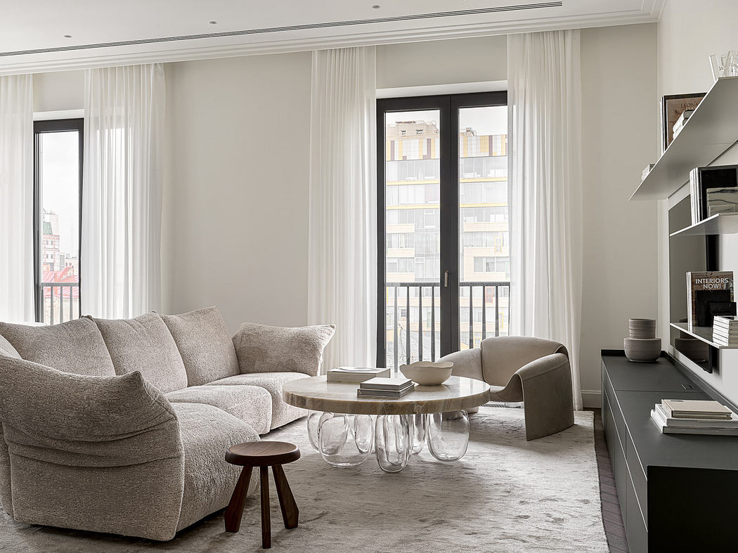Minimalist living room with large windows, plush gray sofa, and wooden coffee table.