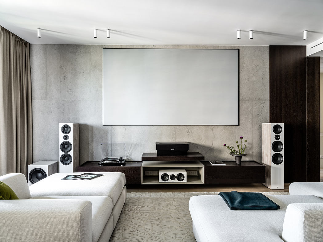 Minimalist home theater with sleek audio equipment, large projection screen, and neutral-toned decor.