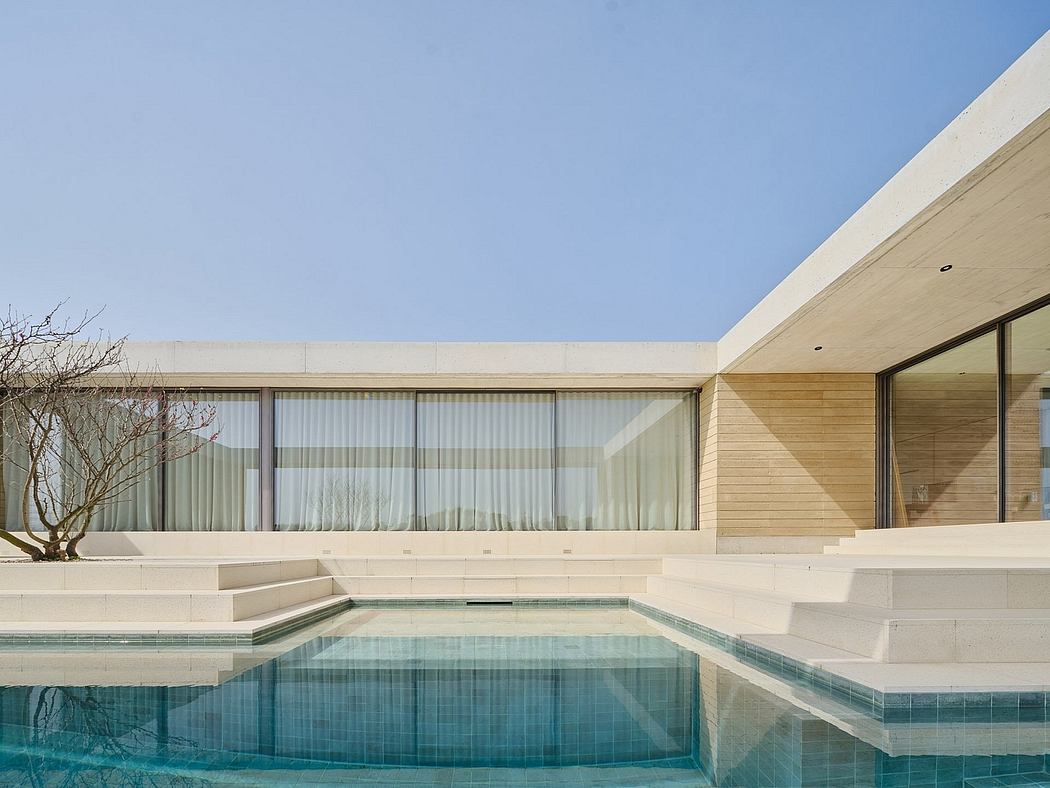 Sleek, modern architecture with clean lines, pool, and glass walls overlooking landscape.