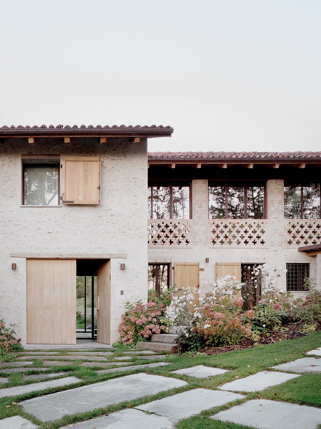 A charming rustic building with ornate wooden details, surrounded by a lush garden.