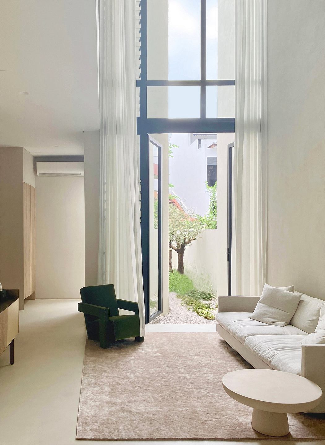Elegant living room with large windows overlooking a serene outdoor garden.