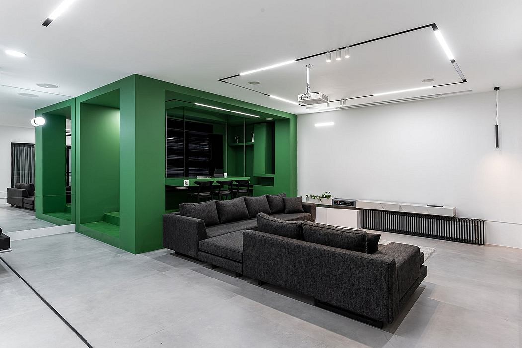 Sleek, modern interior featuring a large green entertainment unit, cozy lounge area, and minimalist lighting.