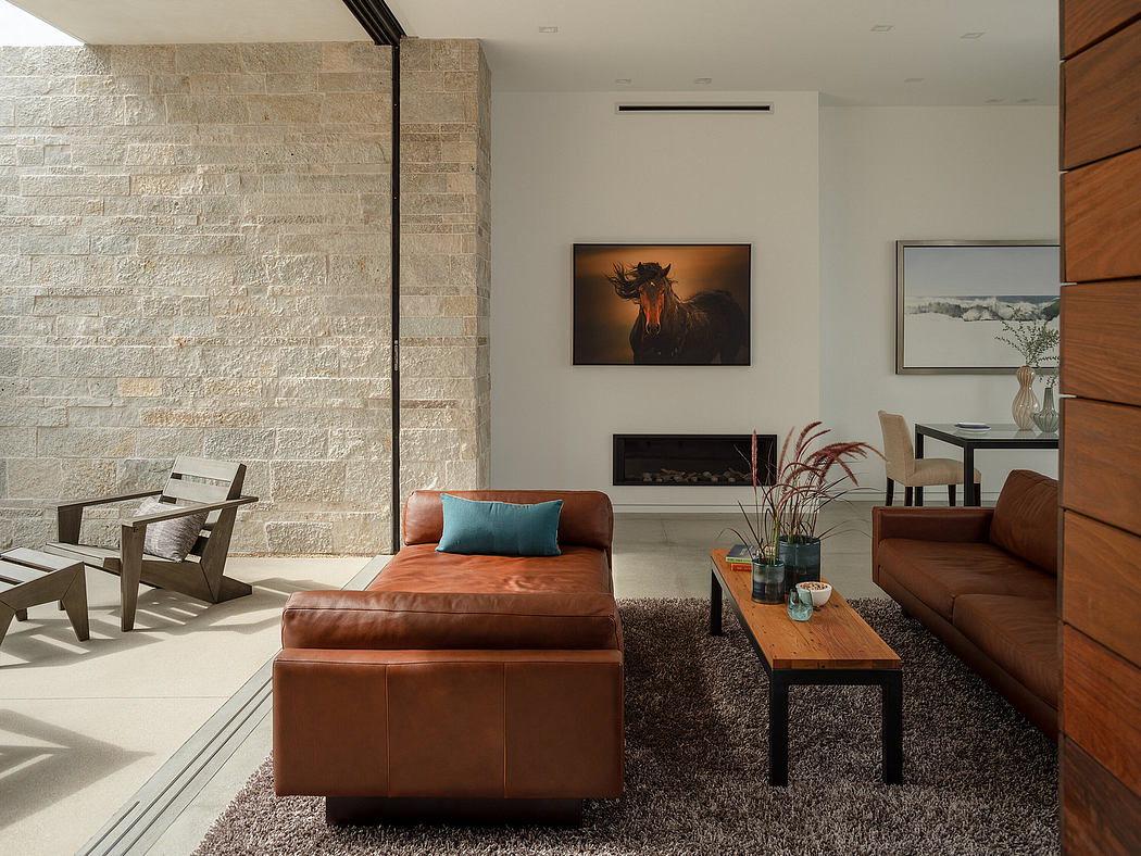 Spacious living room with rustic stone wall, leather furniture, and modern artwork.