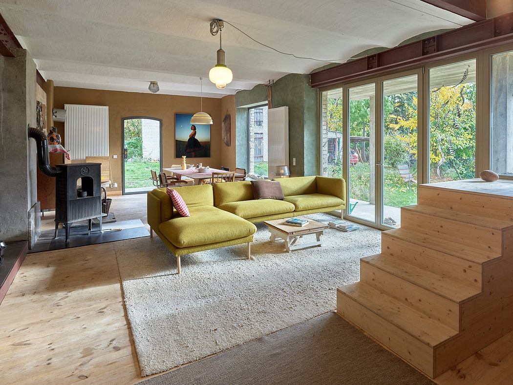 Cozy living room with wooden accents, yellow couch, and large windows overlooking greenery.