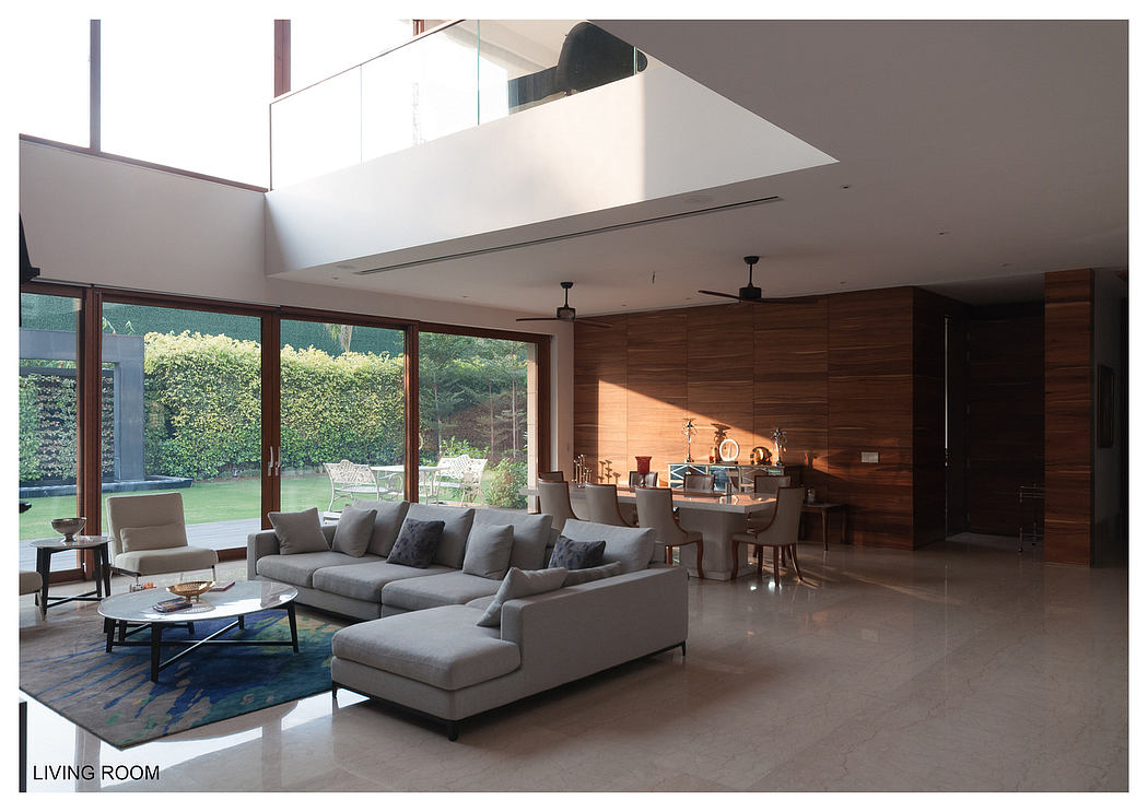 Expansive living room with wooden paneling, large windows, and a modern furniture layout.