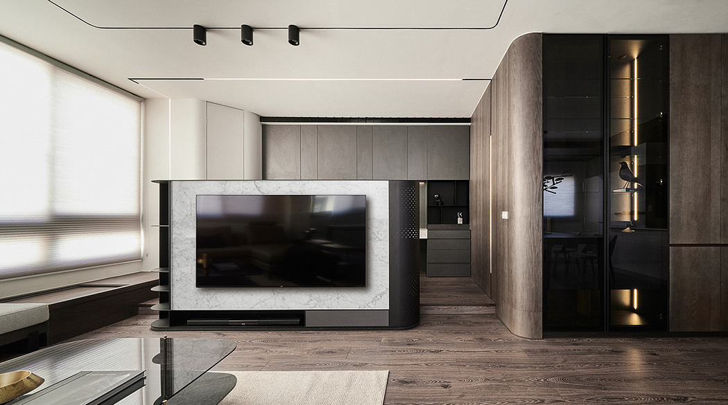 Modern and minimalist living room with sleek TV console, wood-paneled walls, and recessed lighting.