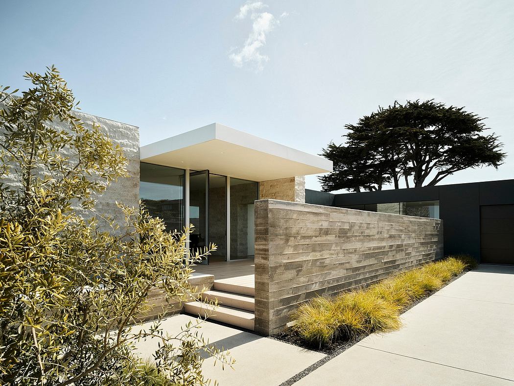 Contemporary architectural design featuring clean lines, stone walls, and lush landscaping.