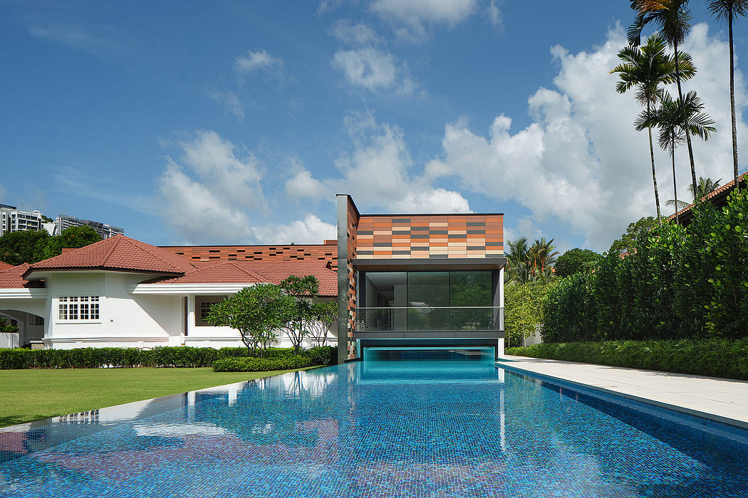 A modern tropical residence with a vibrant tile facade, sleek pool, and lush landscaping.