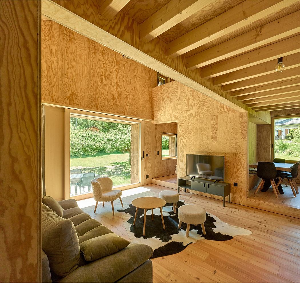 Warm-toned wood paneling, high ceilings, and large windows create a cozy, nature-inspired space.