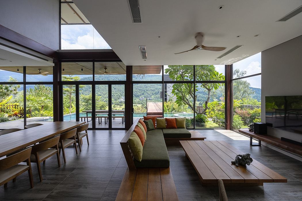 Expansive glass walls offer panoramic views of lush, tropical landscape.