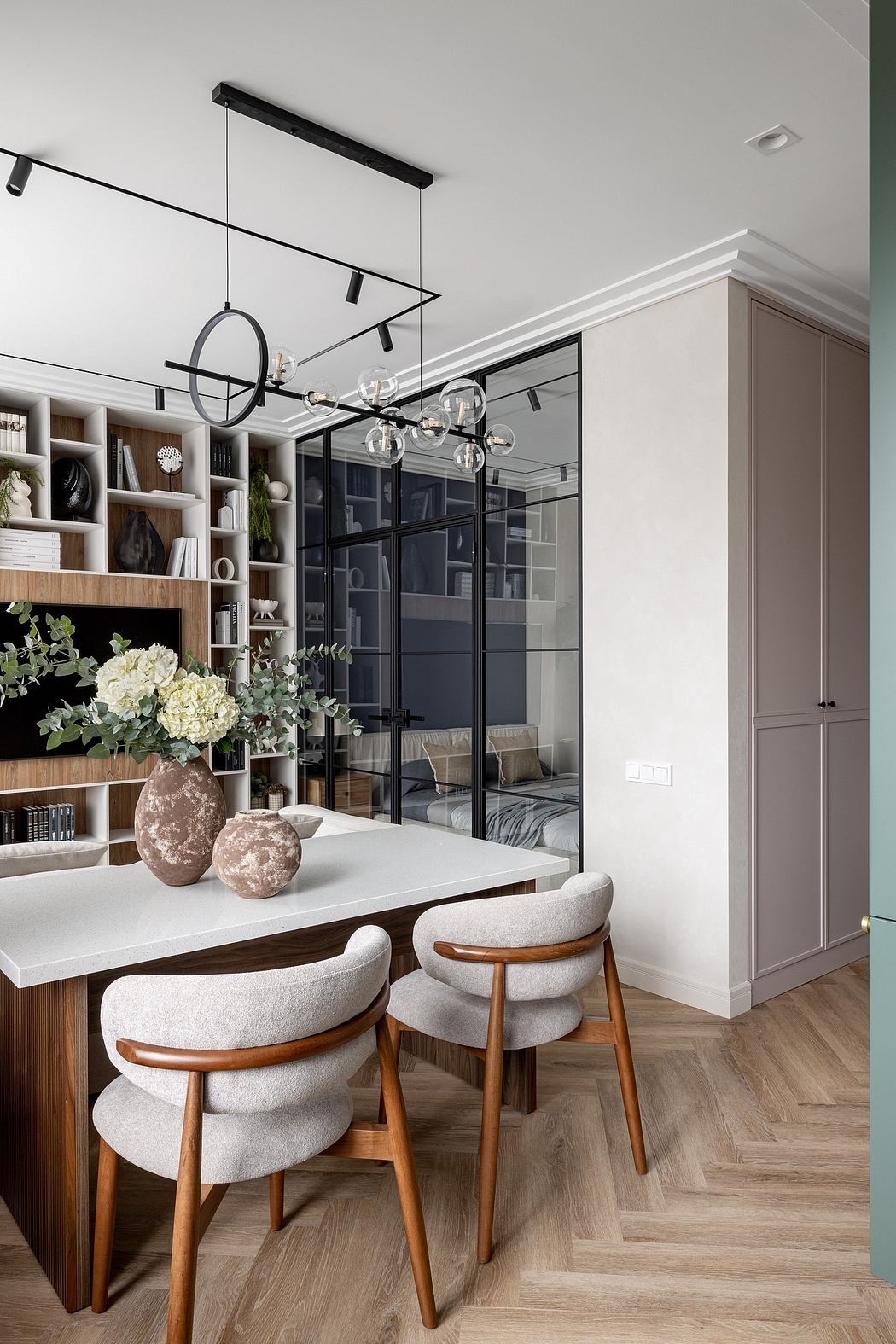 Elegant contemporary dining space with minimalist lighting, shelving, and wood accents.