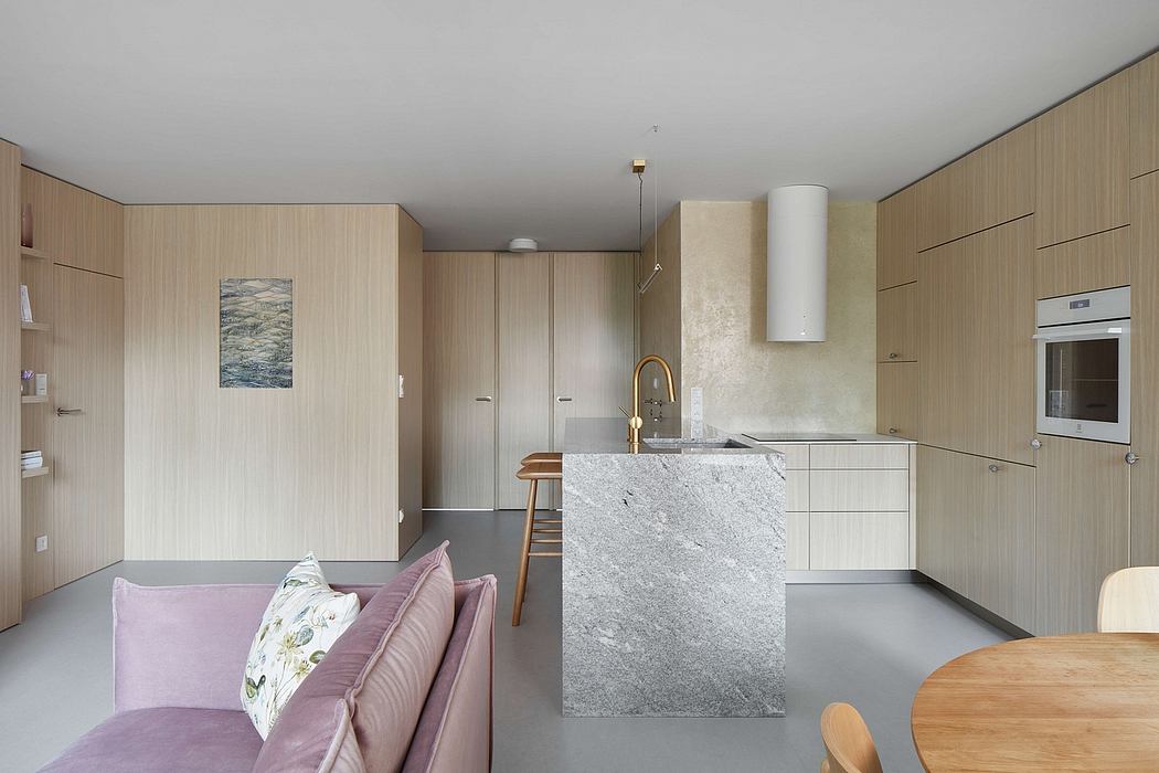 Spacious open-plan kitchen with sleek, modern cabinetry and stone island countertop.