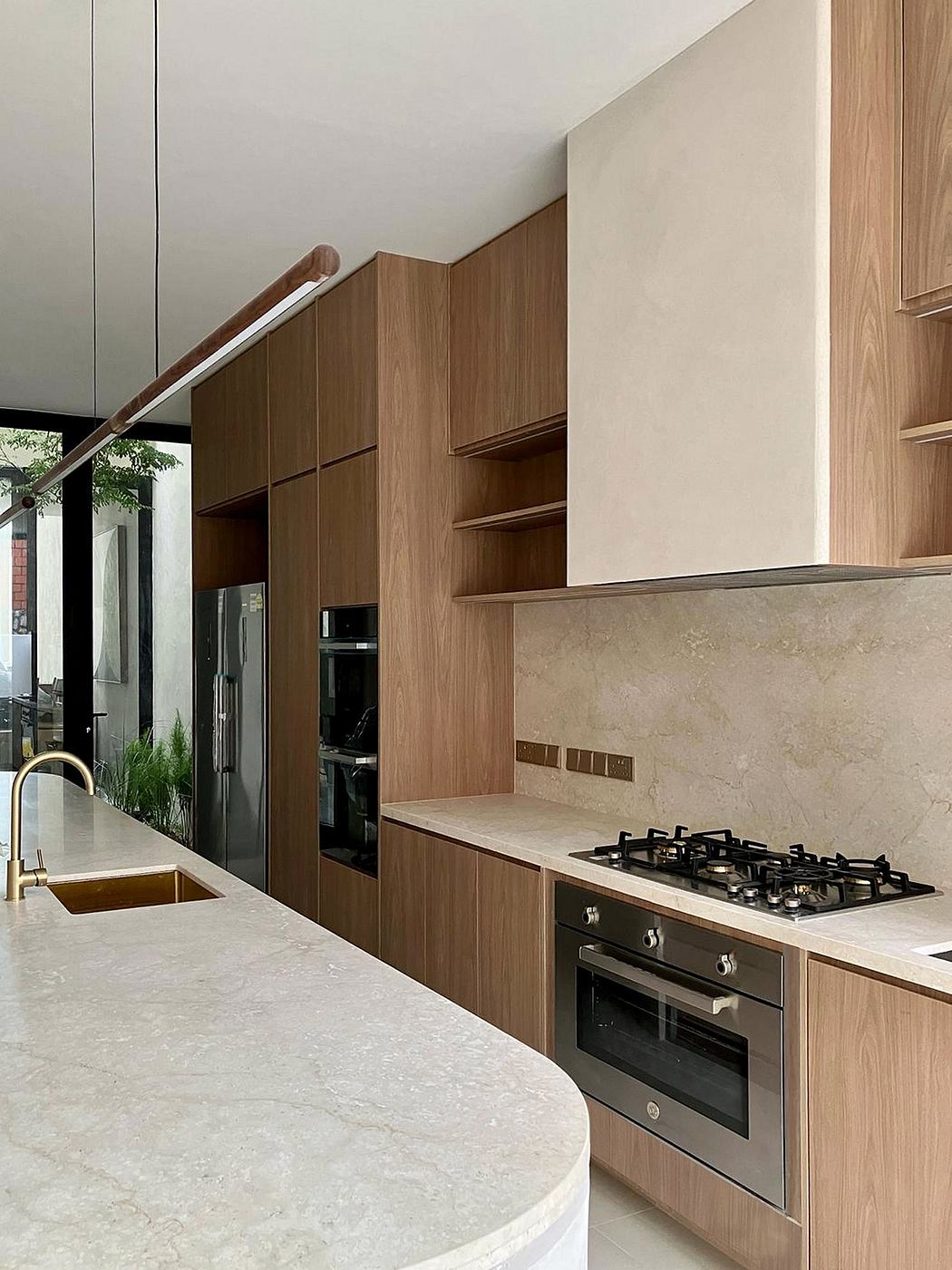 A modern kitchen with sleek, wood-paneled cabinets and a marble countertop, featuring built-in appliances.