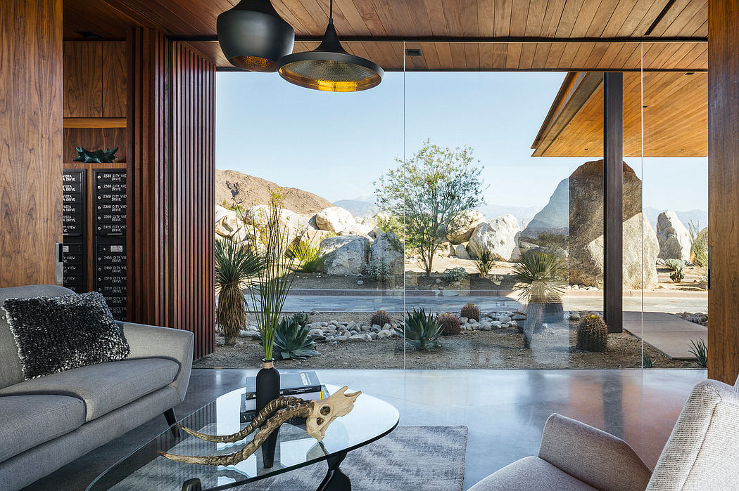 Sleek modern living space with large glass windows framing a desert landscape.
