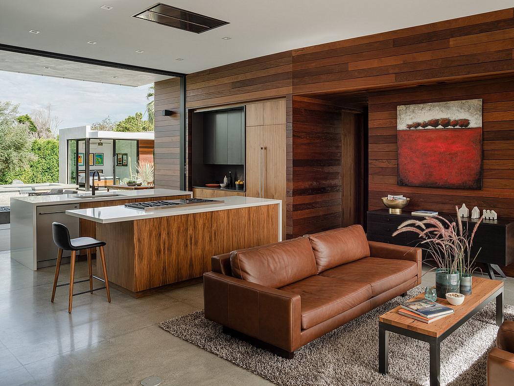 Sleek, modern kitchen with wood and concrete accents, open to a cozy living area.