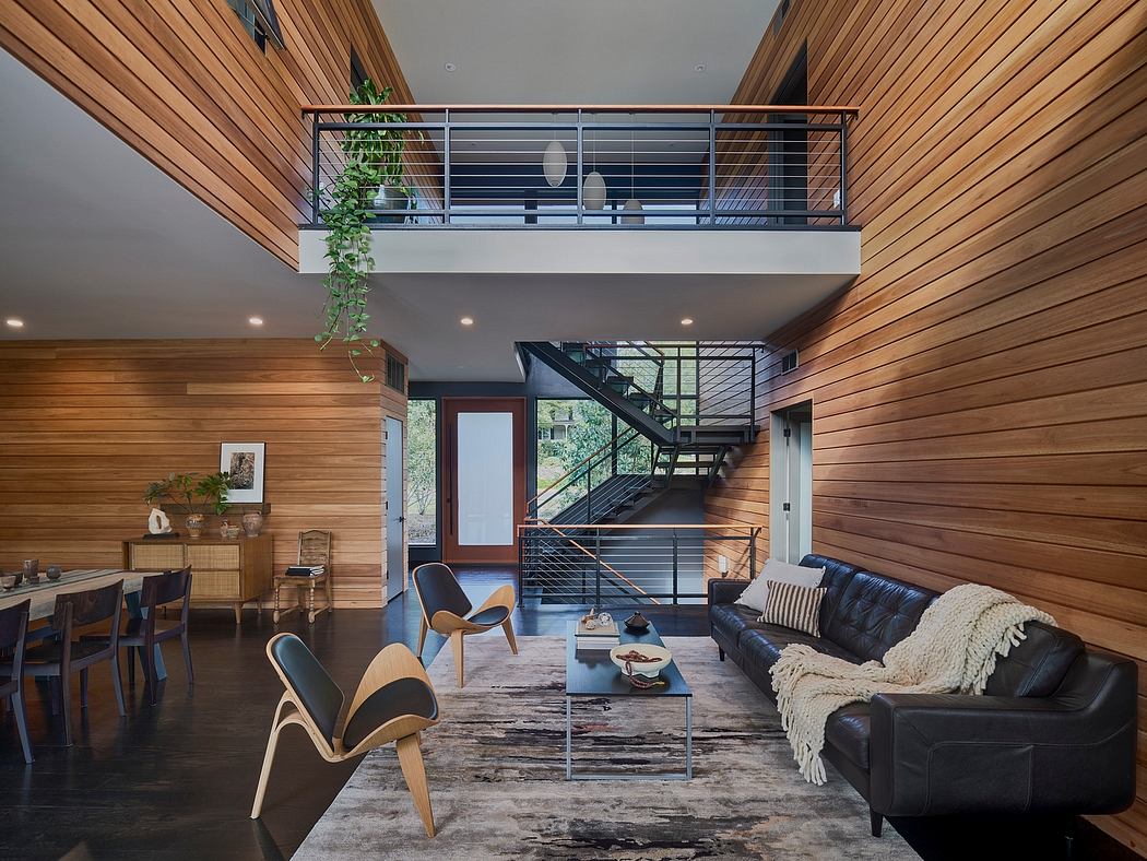 An open-concept living space with natural wood paneling, modern furnishings, and a sleek mezzanine.