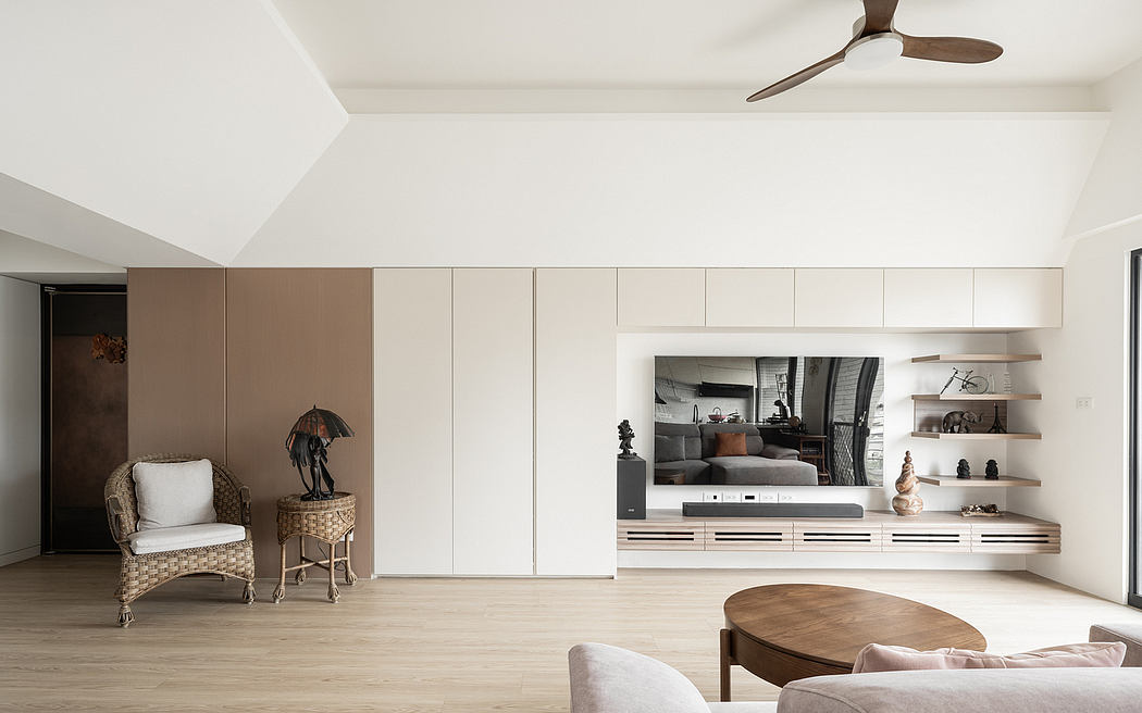 Modern, minimalist living room with sleek cabinets, floating shelves, and a ceiling fan.