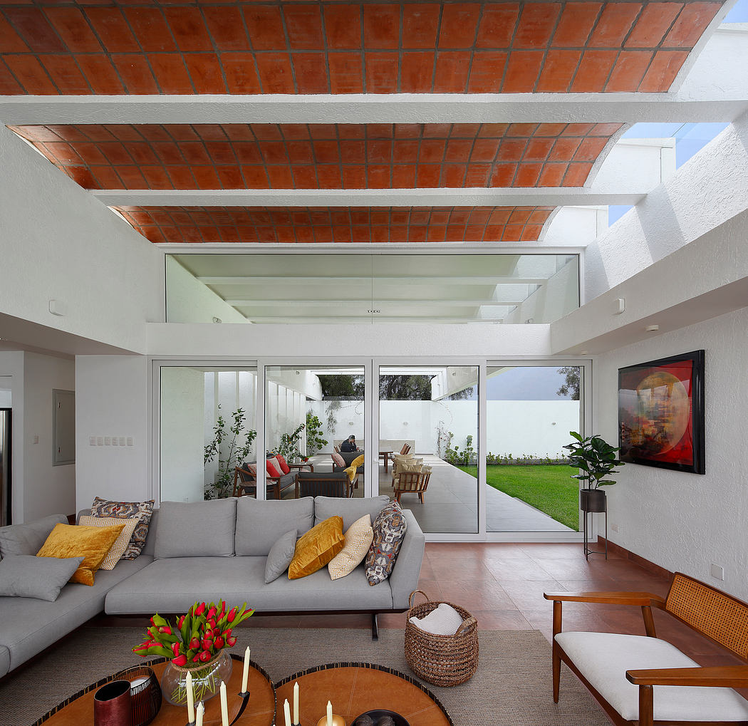 Spacious open-concept living room with exposed brick ceiling, large glass doors, and modern furnishings.