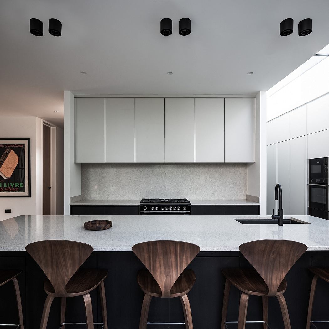 Sleek, minimalist kitchen with high-gloss cabinets, wood bar stools, and modern appliances.