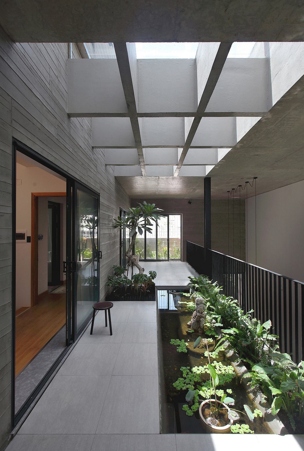 The image showcases a modern, minimalistic indoor space with a lush, green plant display.