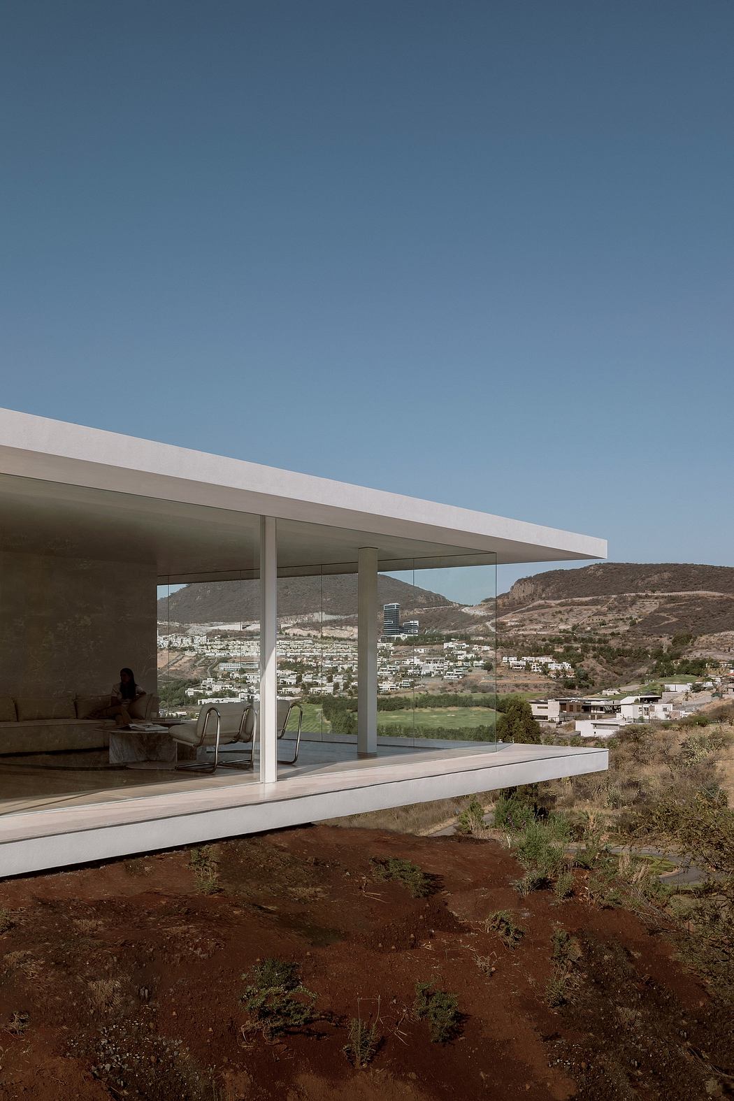 Modern architectural structure with expansive glass walls showcasing a scenic landscape in the background.