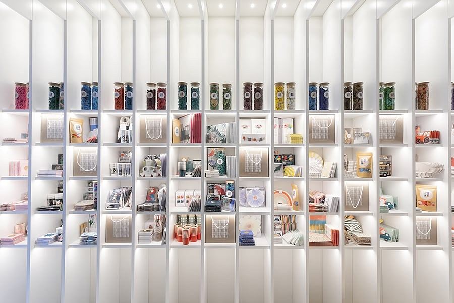 Organized, minimalist storage display with uniform white shelves and a variety of organized items.