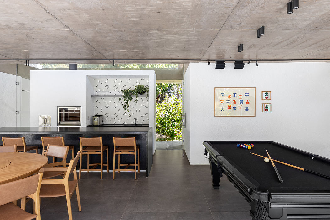 Contemporary open-plan home with concrete ceiling, wooden furnishings, and decorative wall motifs.